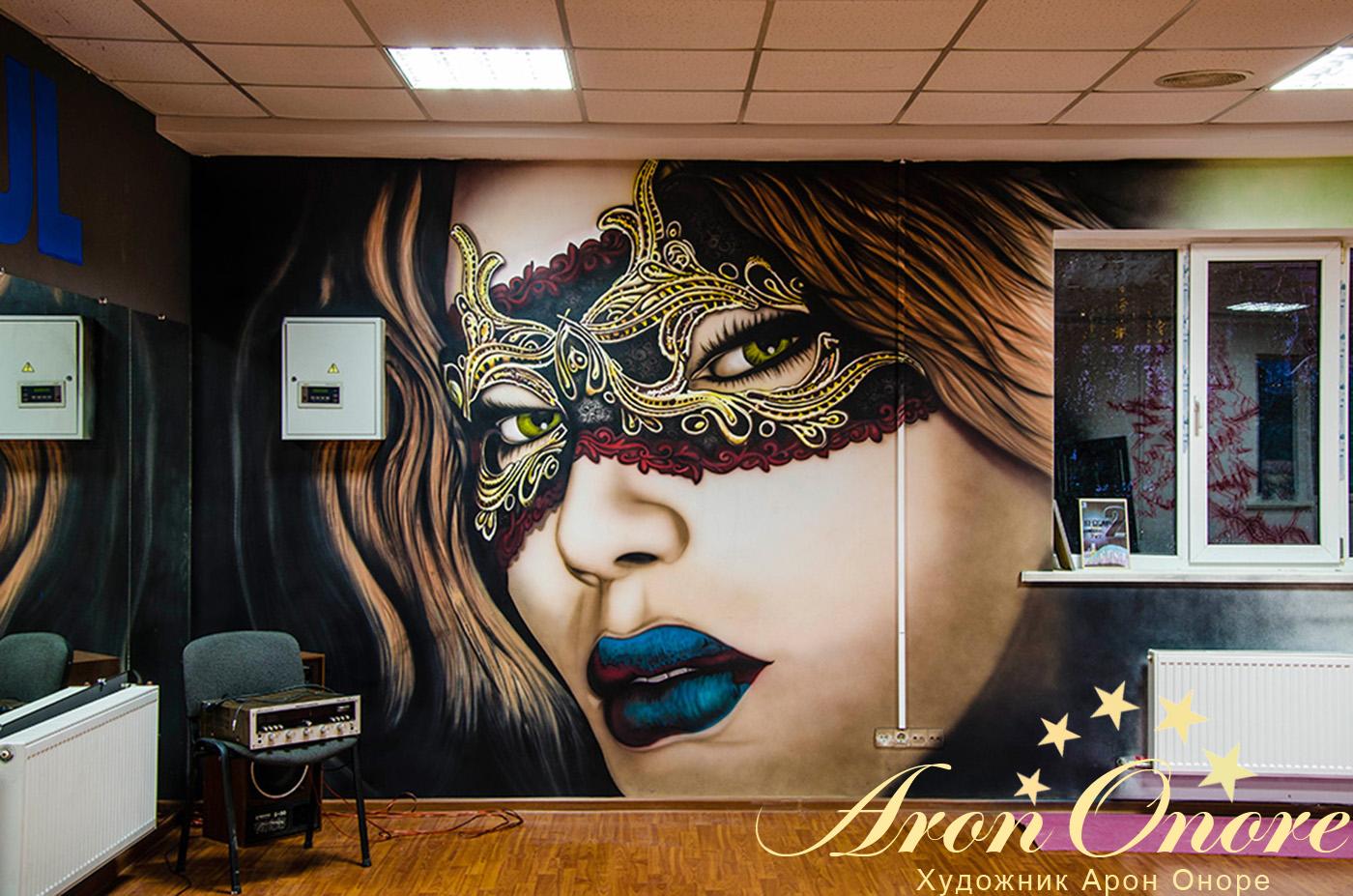 Лицо девушки в маске – рисунок на стене в комнате для танцев