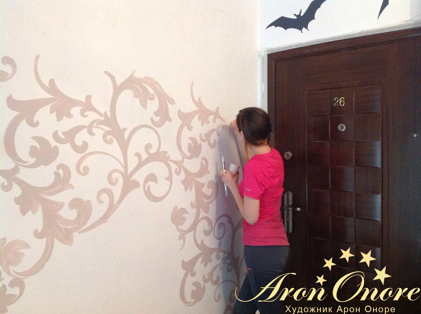 Художница Дарья Оноре – в процессе росписи стены подъезда (рисует узоры на стене)