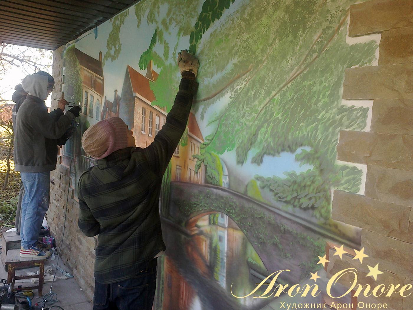 Художники занимаются росписью фасада здания