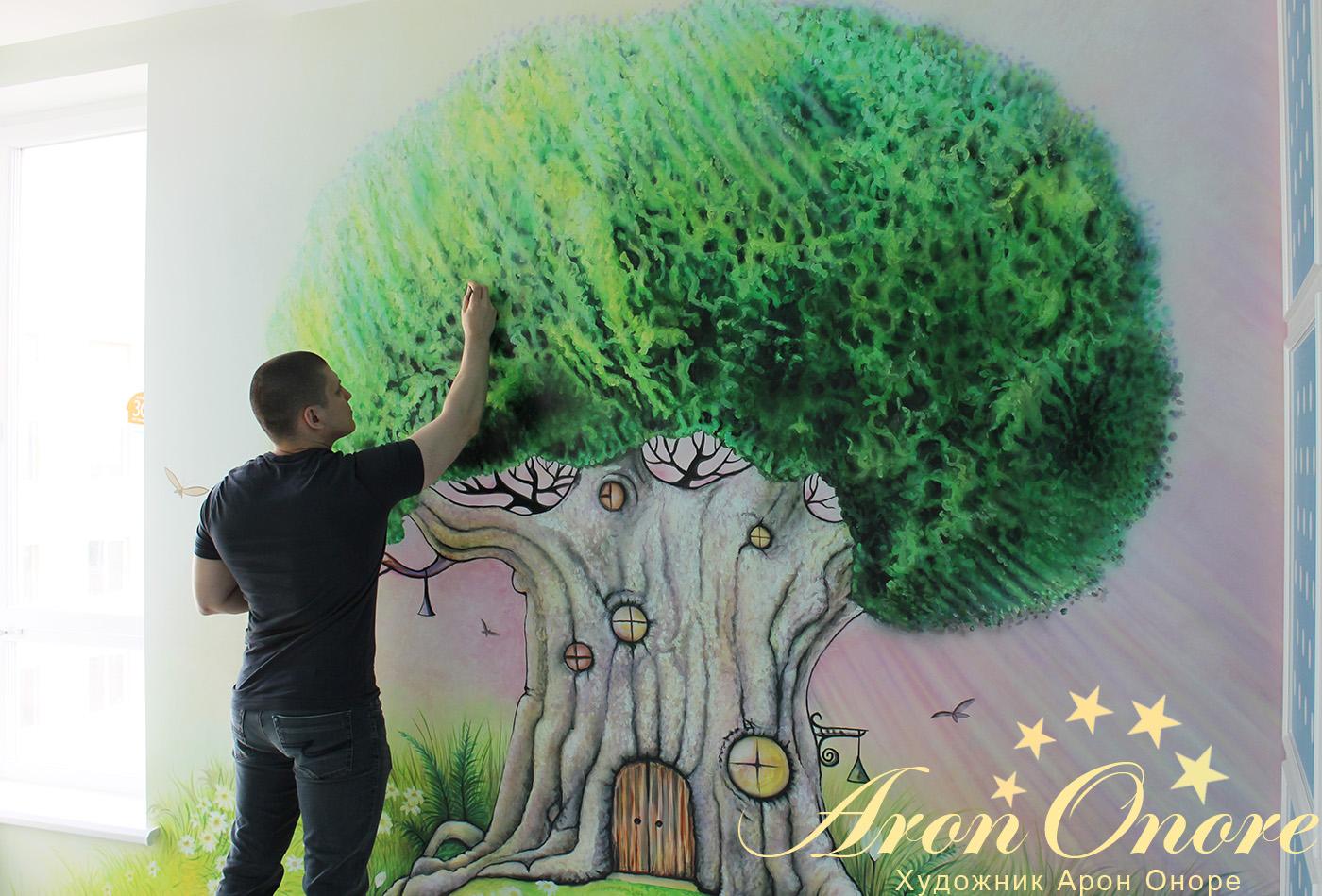Арон Оноре рисует сказочный лес на стене детской игровой комнаты