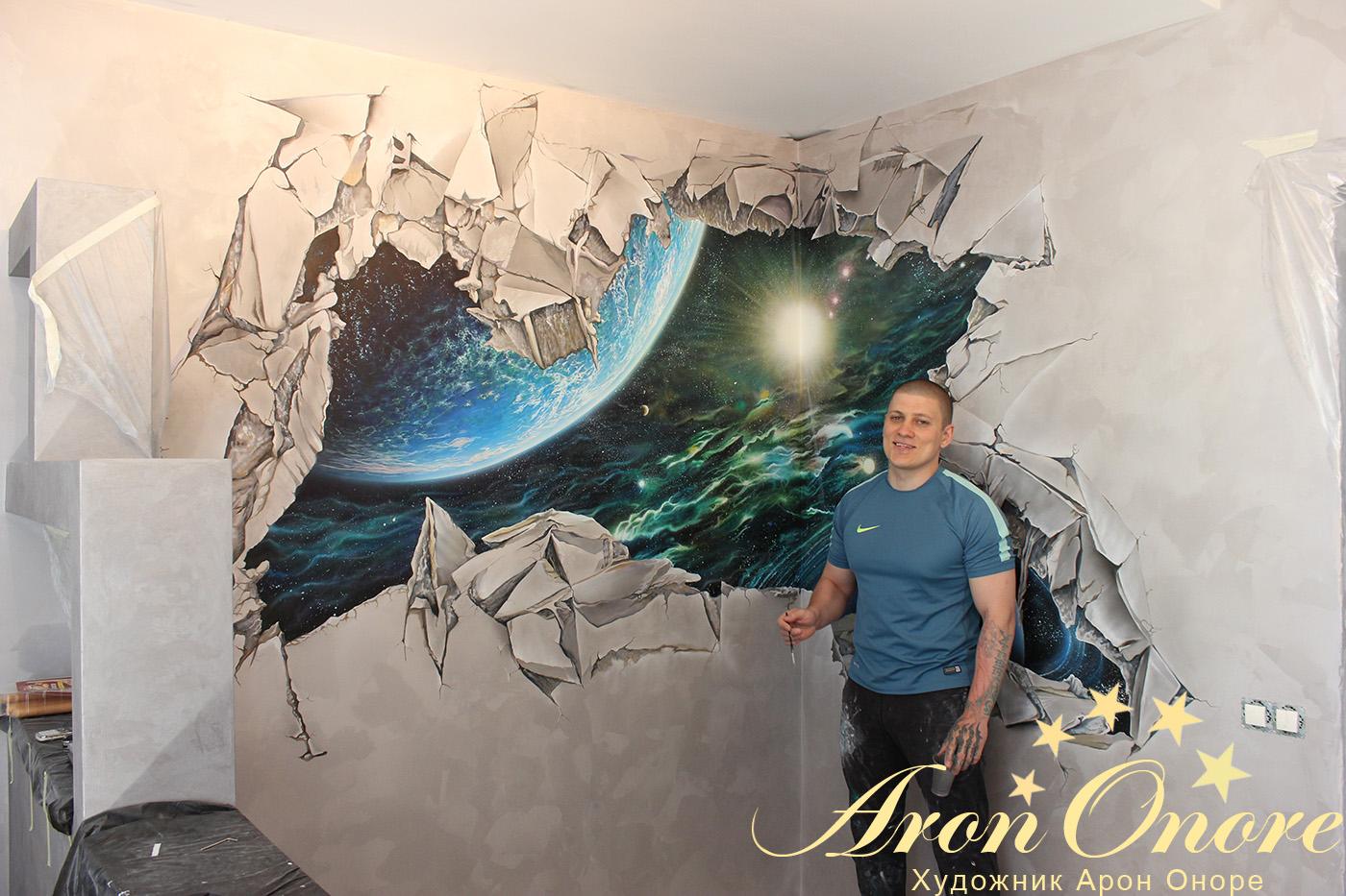 Художник Арон Оноре на фоне рисунка на стене – Выход в космос