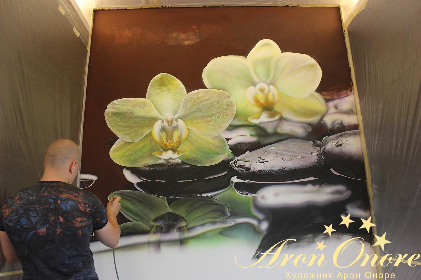 Художник Арон Оноре – рисует на стене зеленый стебель цветка