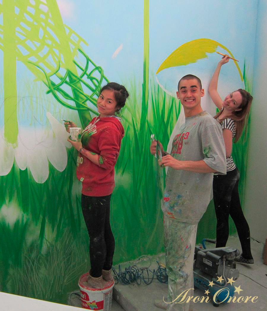 Художники с улыбкой занимаются художественной росписью стен