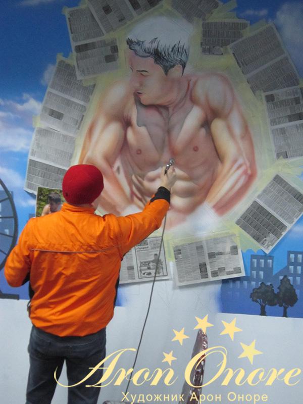 Арон Оноре занимается созданием рисунка на стене в спортивном клубе